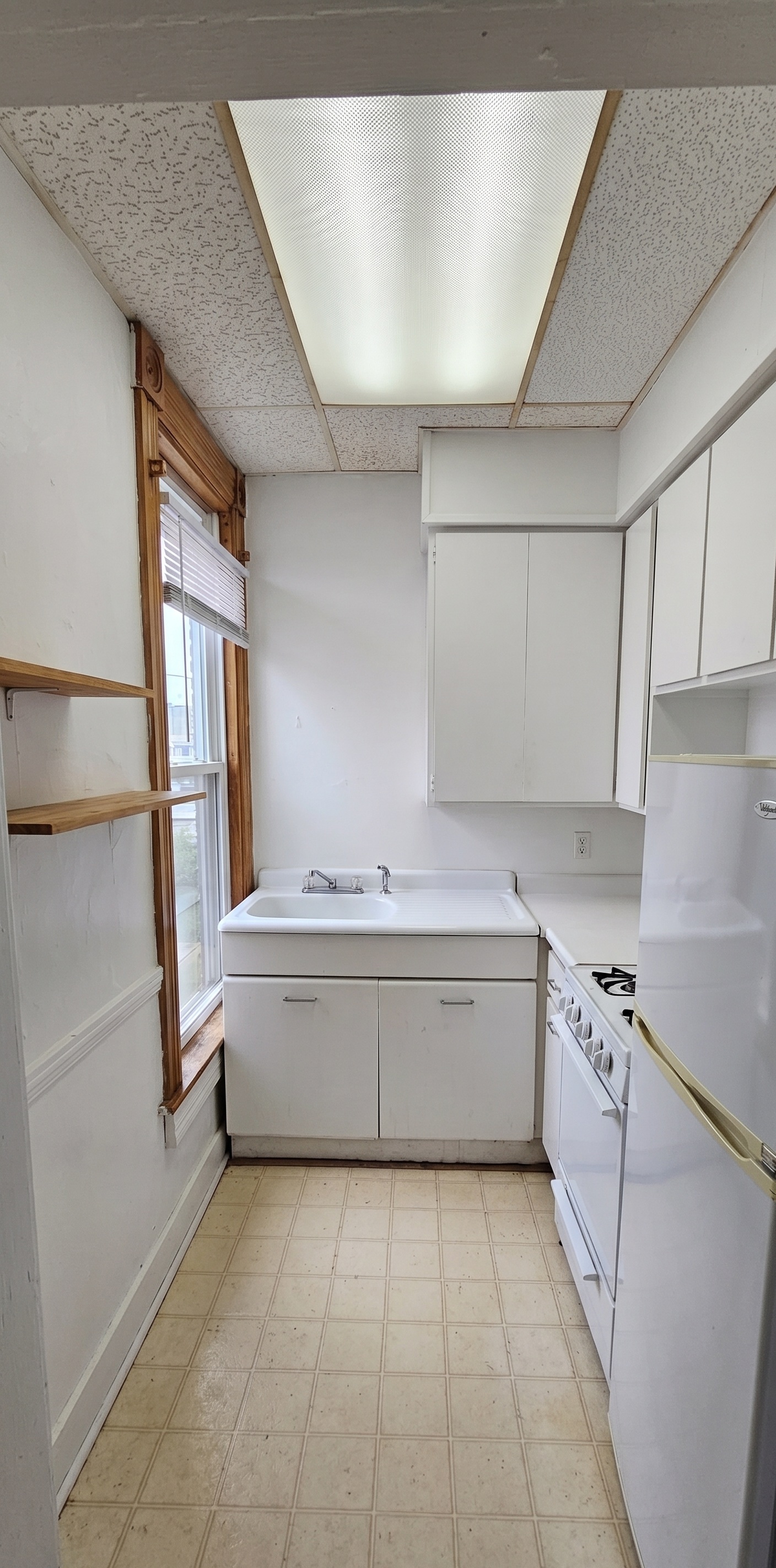 306 Unit 2 Kitchen — galley kitchen with white cabinets and gas stove